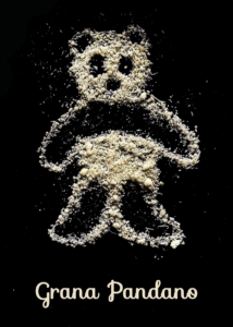 Grana Pandano; Wortwitz; ein Pandabär aus Hartkäse (Grana Padano) gelegt auf schwarzem Hintergrund